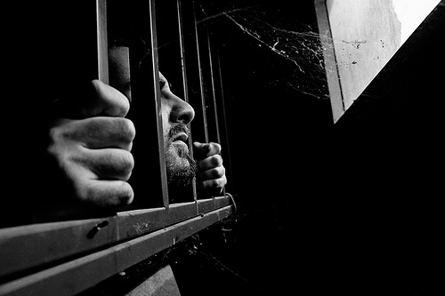 Man with head poking out of jail cell